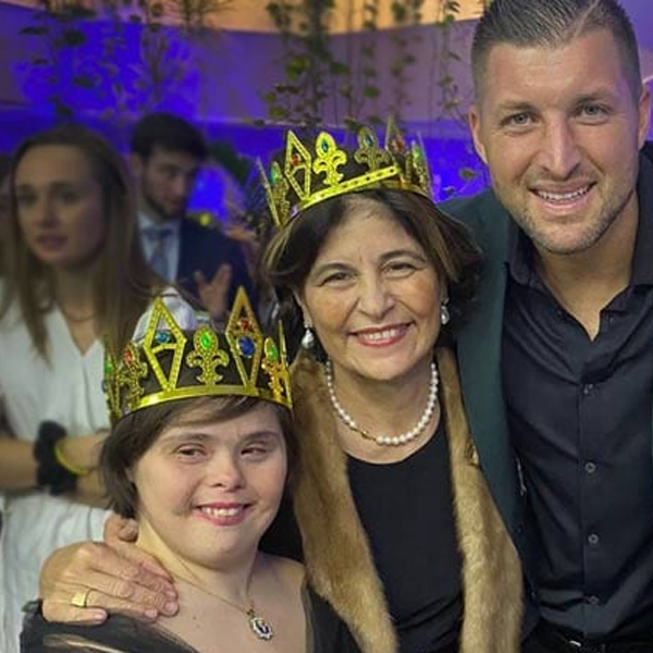 Tim Tebow with a mother and daughter at a Night to Shine